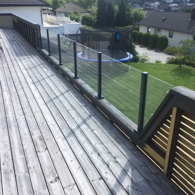 Glassrekkverk på mørkbeiset veranda