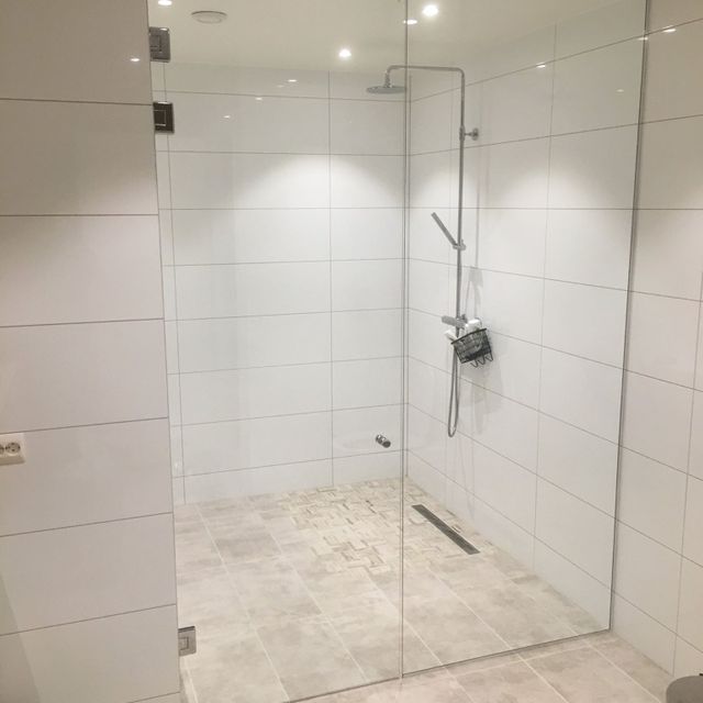 Glassdører til dusj på lyst bad